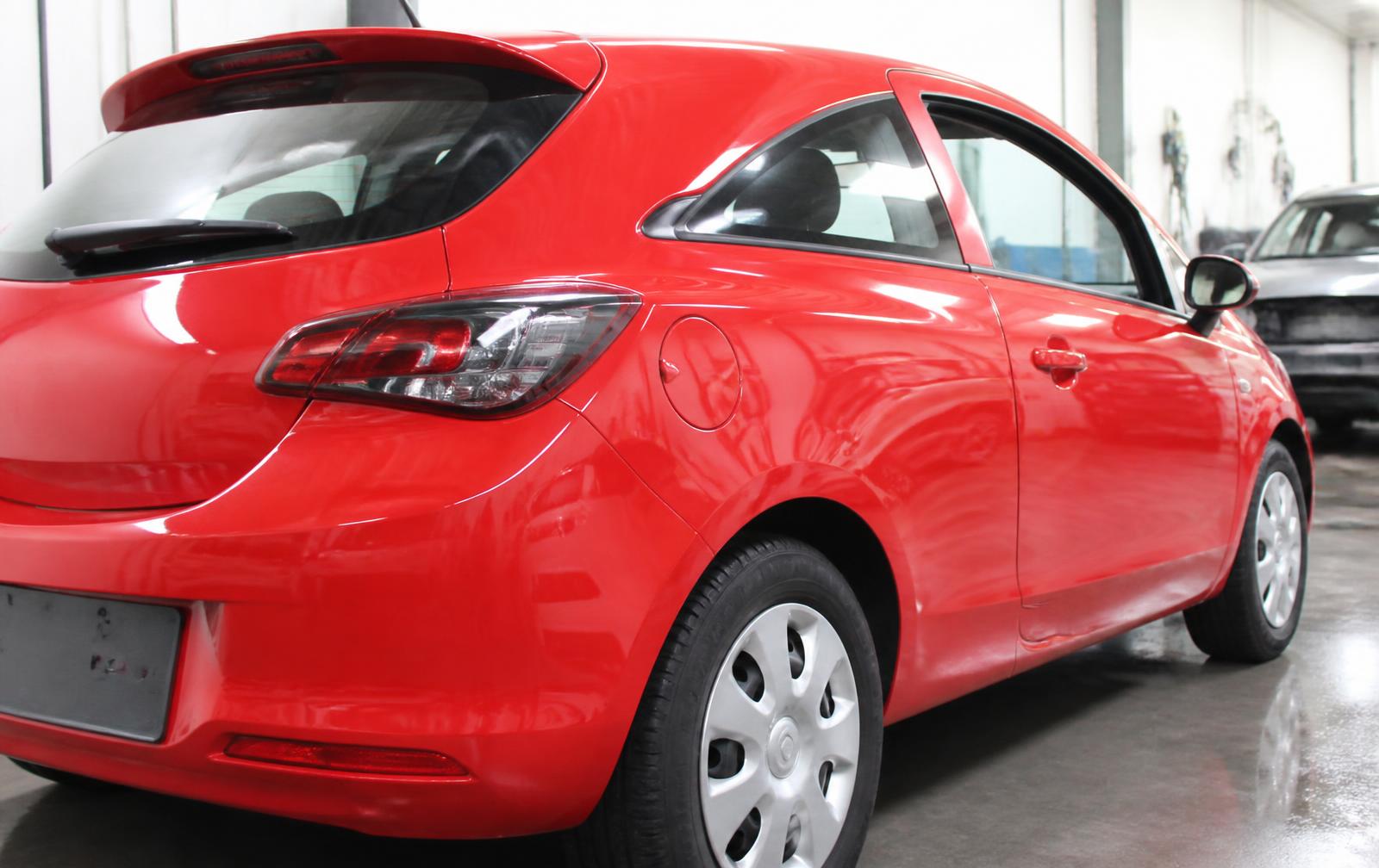 Red Vauxhall Corsa rear wing before and after dent repair — after